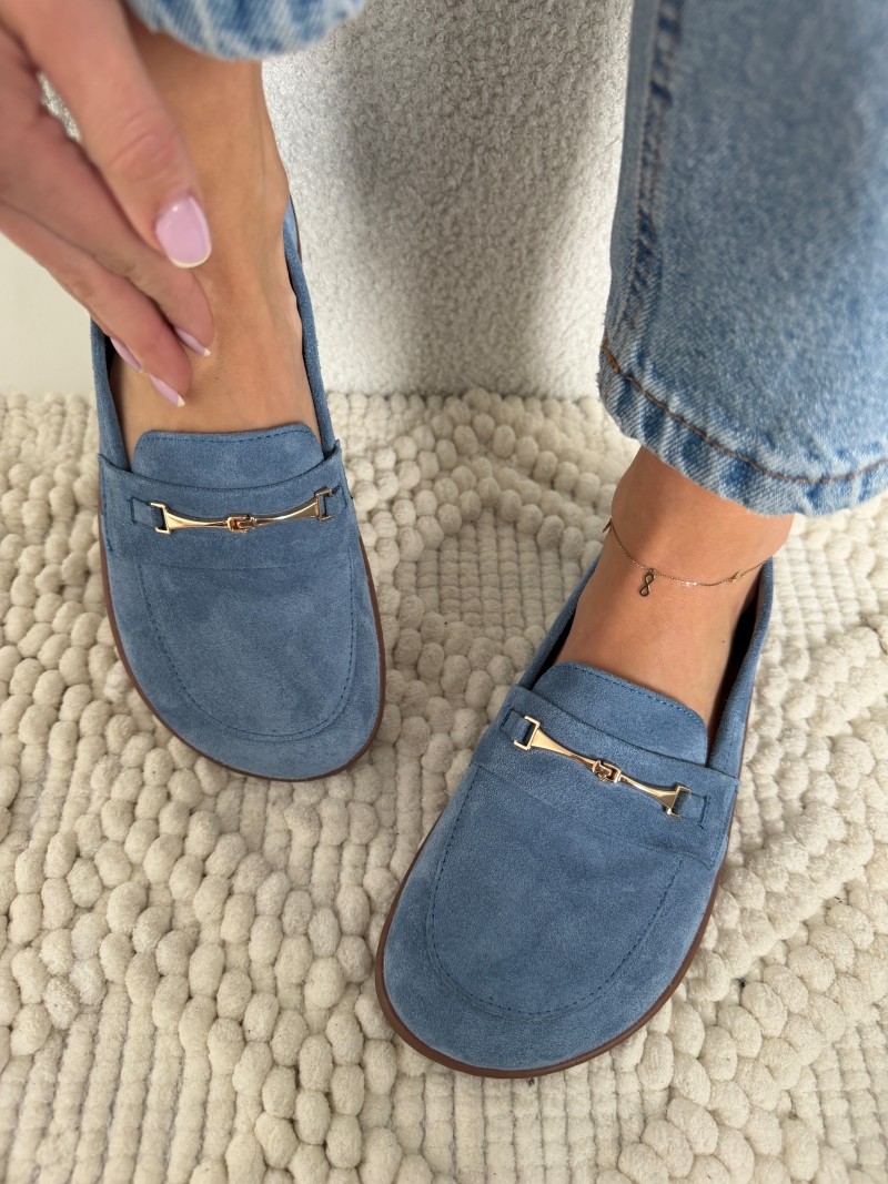 Niebieskie zamszowe mokasyny damskie Evett Florence z złotą klamrą, widok z góry na nodze modelki w jeansach, na jasnym dywanie